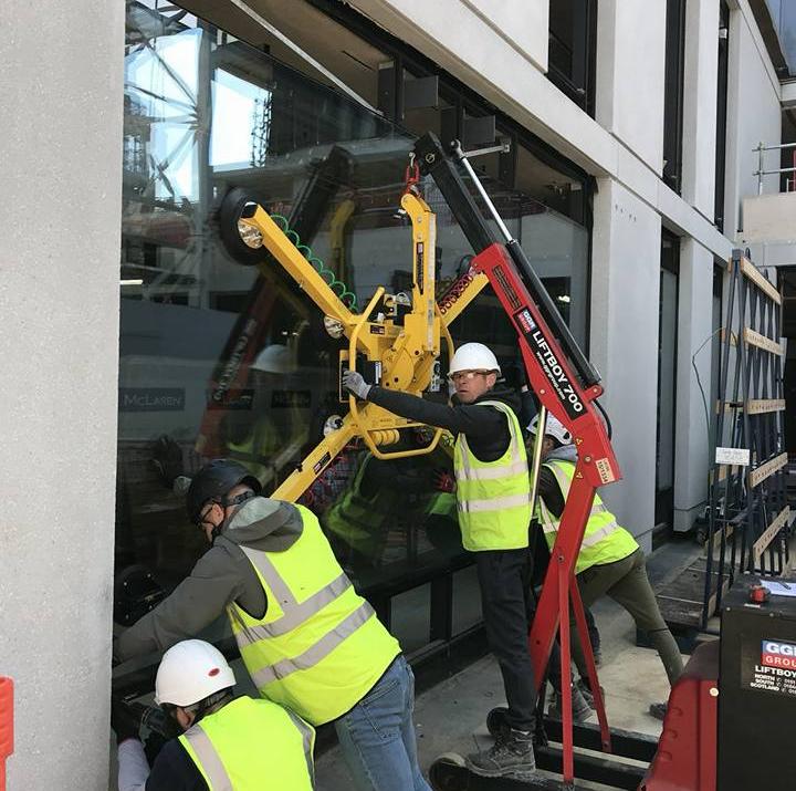Site crew handling a facade panel